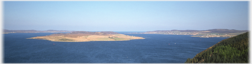 Wide angle shot of the loch with low island in the centre.