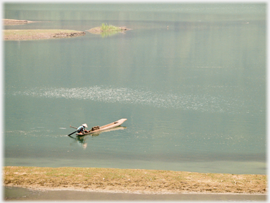 Woman in boat with fish-traps.