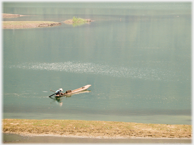 Woman in boat with fish-traps.