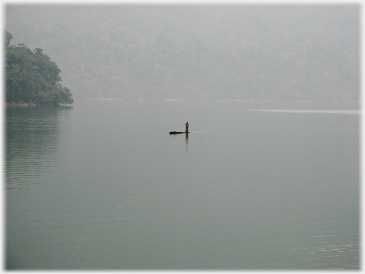 Small boat on a large empty lake at evening.