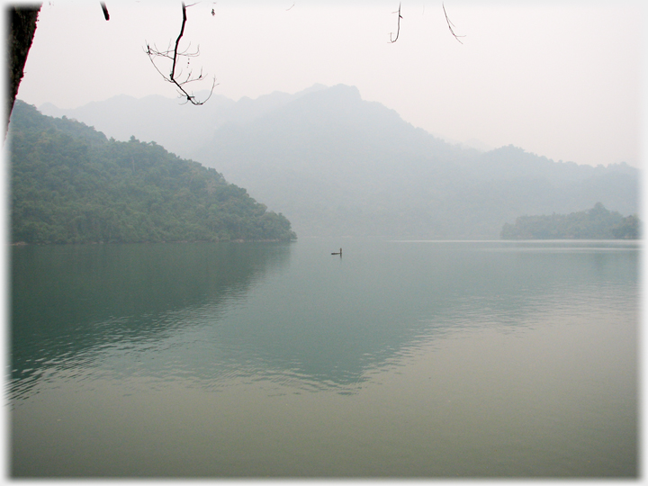 Boat on the lake with mountains behind.