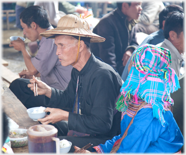 Man in hat eating.