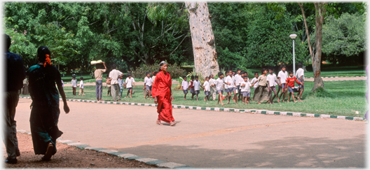 Woman in red sari and troup of school children.
