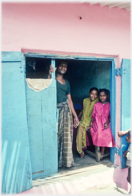 Family at door of pink house.