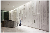 Worker cleaning marble wall.