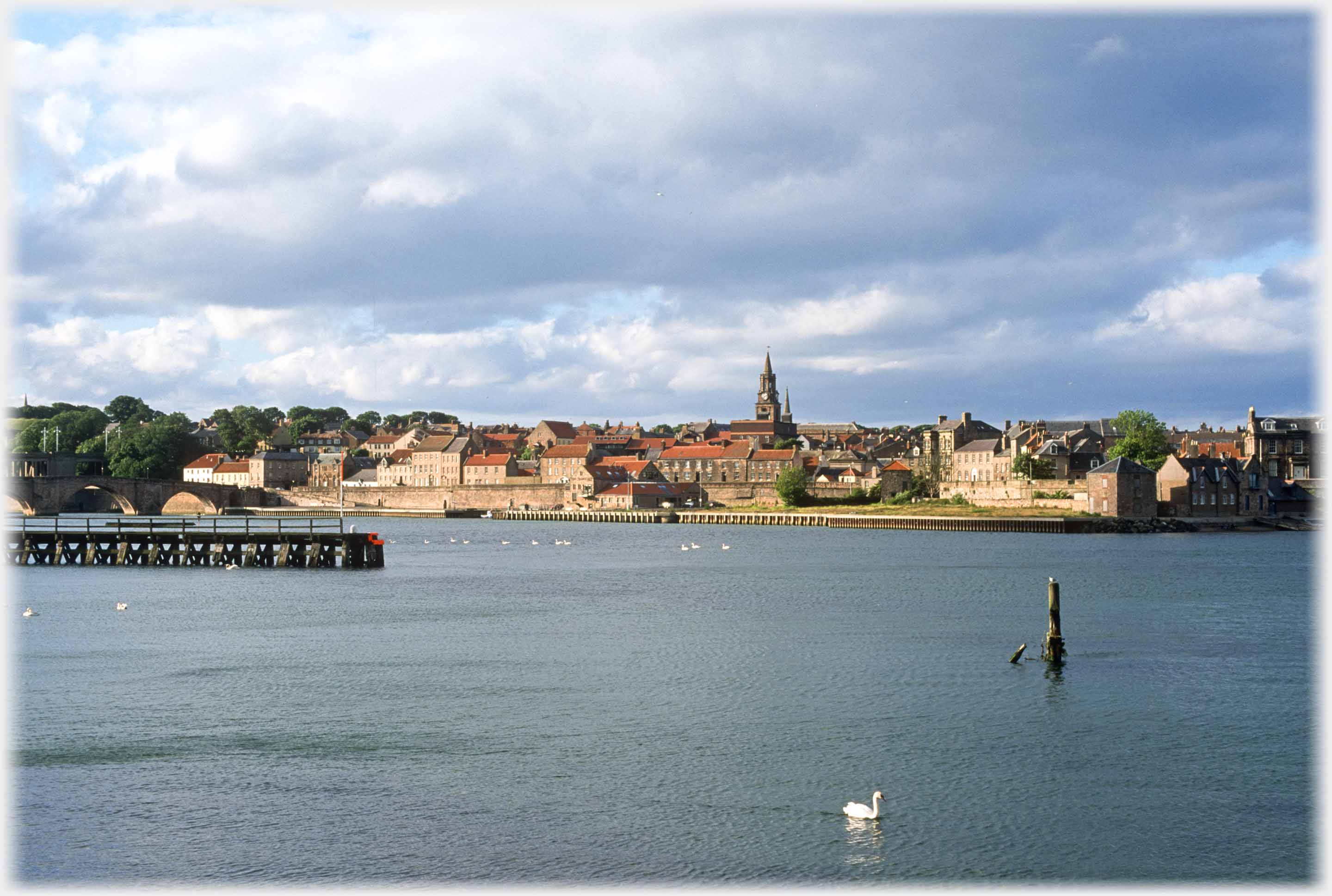 Town seen across river in setting sun.