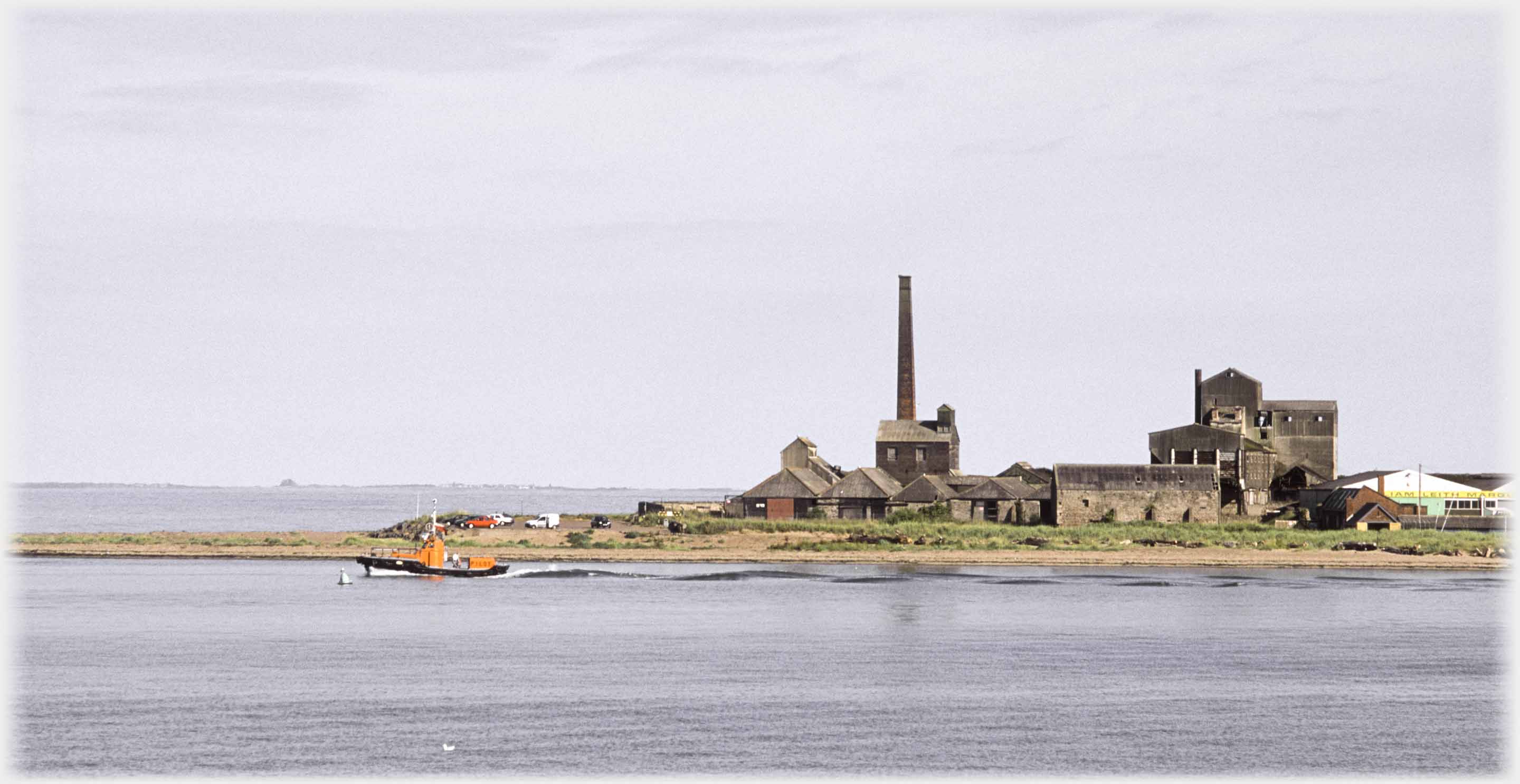 Factory, chimney, lifeboat passing, horizon Lindisfarne Castle.