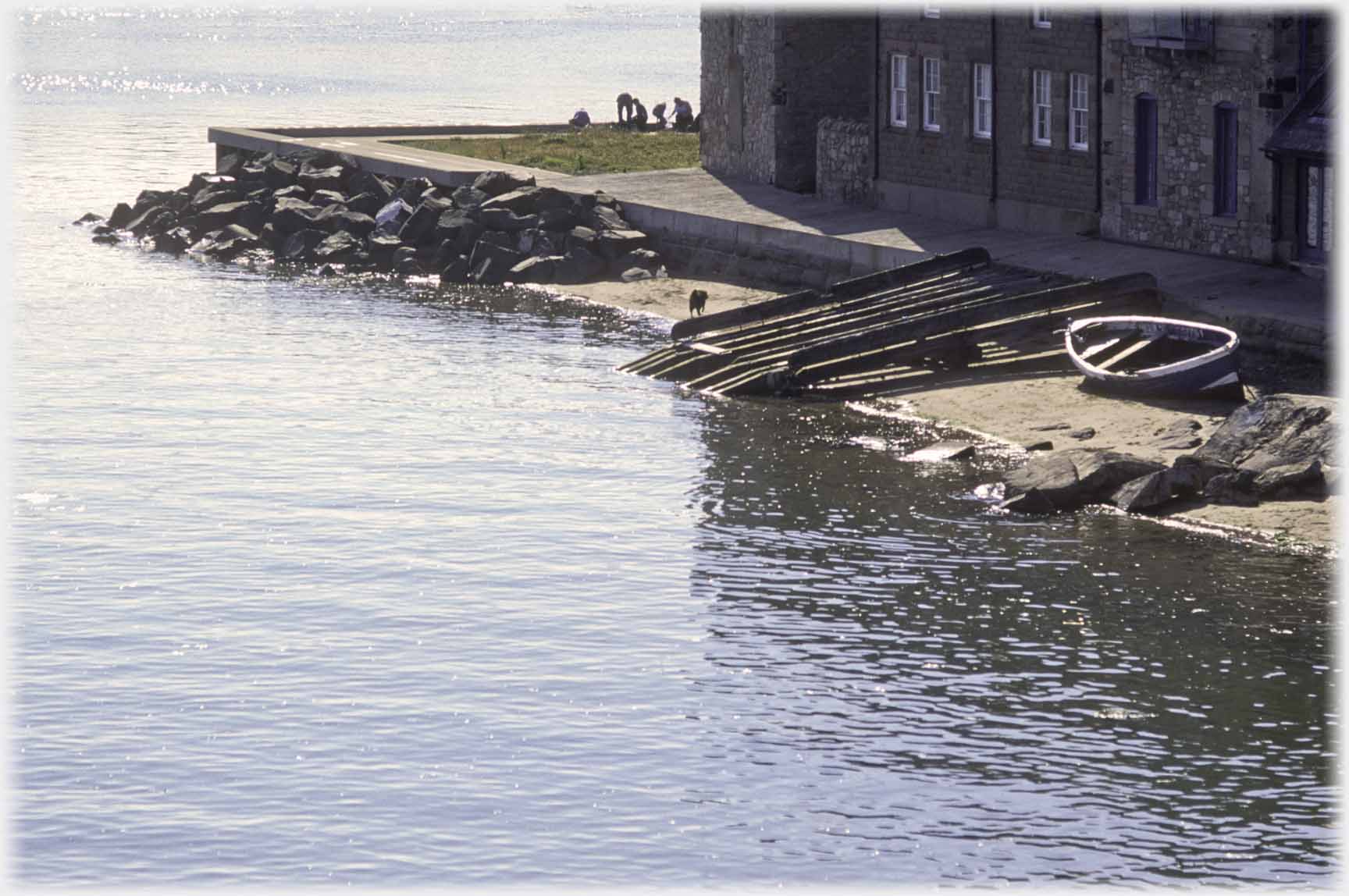 Ramp into water by building and small boat.