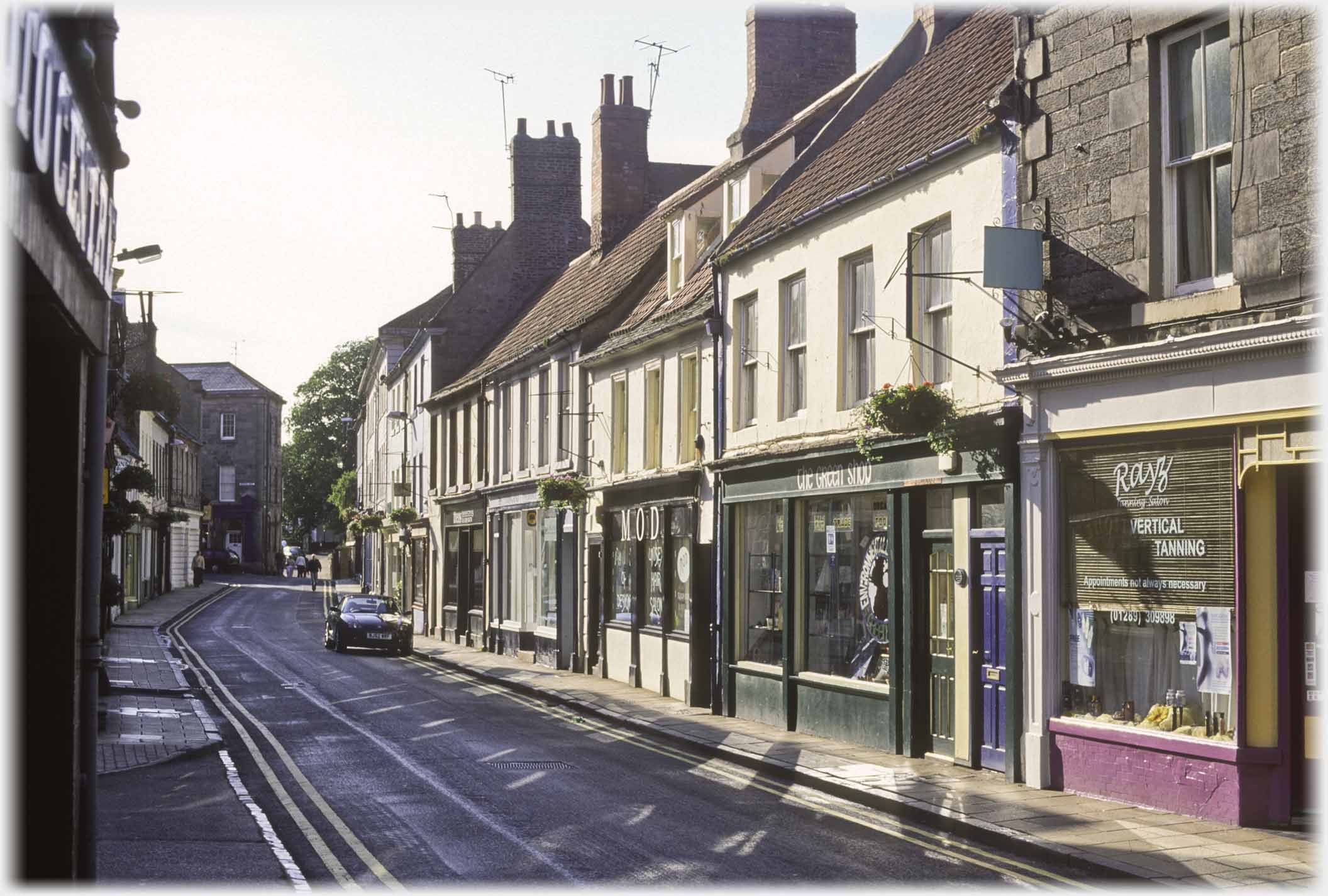 Curving shopping street in evening light.