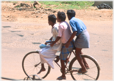 Three men on a bicycle.