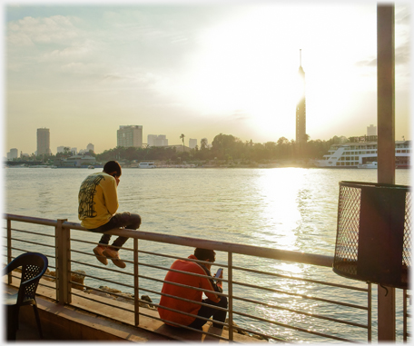 Men phoning at sunset.