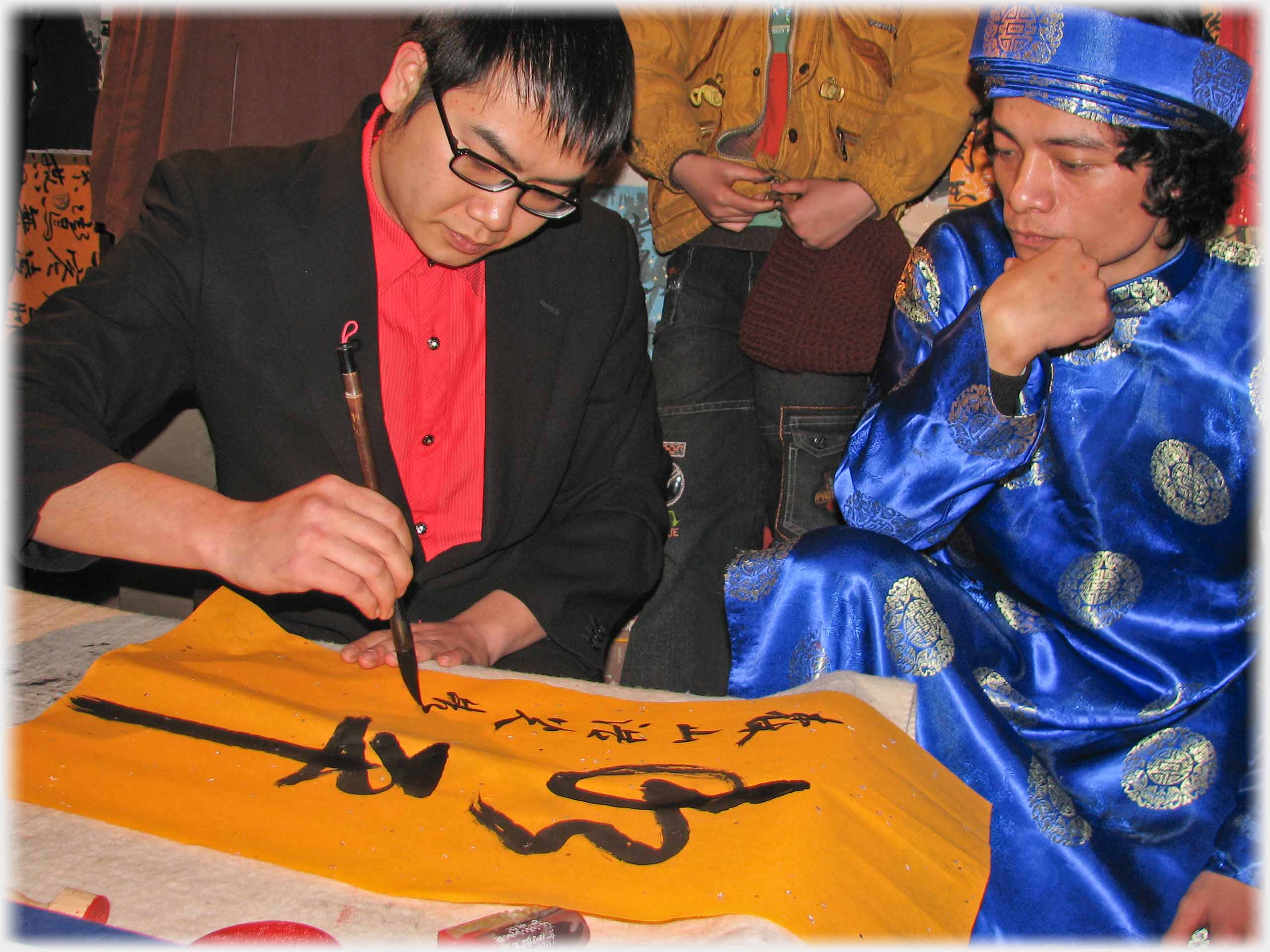 Man in blue costume watching second man write.