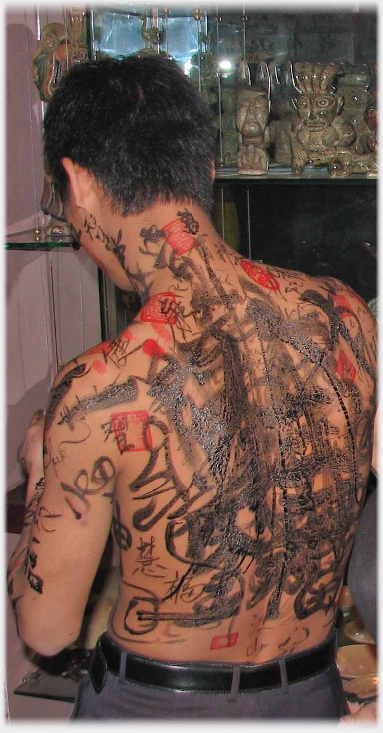 Man's back covered in ink markings.