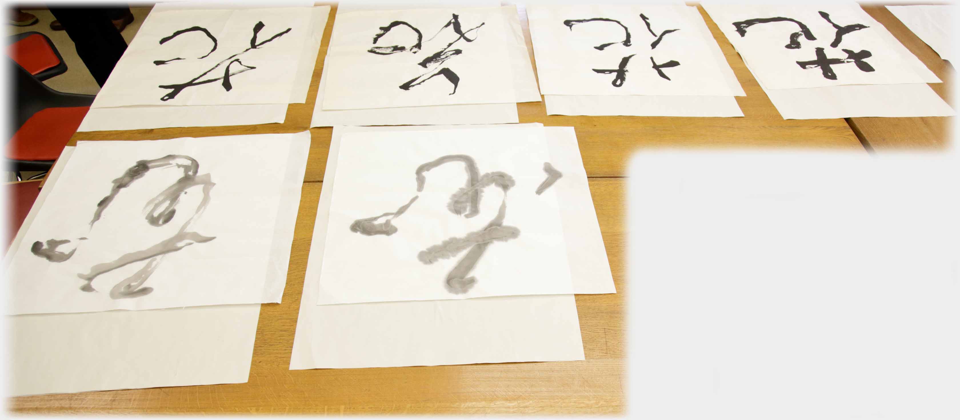 Six characters on large sheets of paper laid on table.