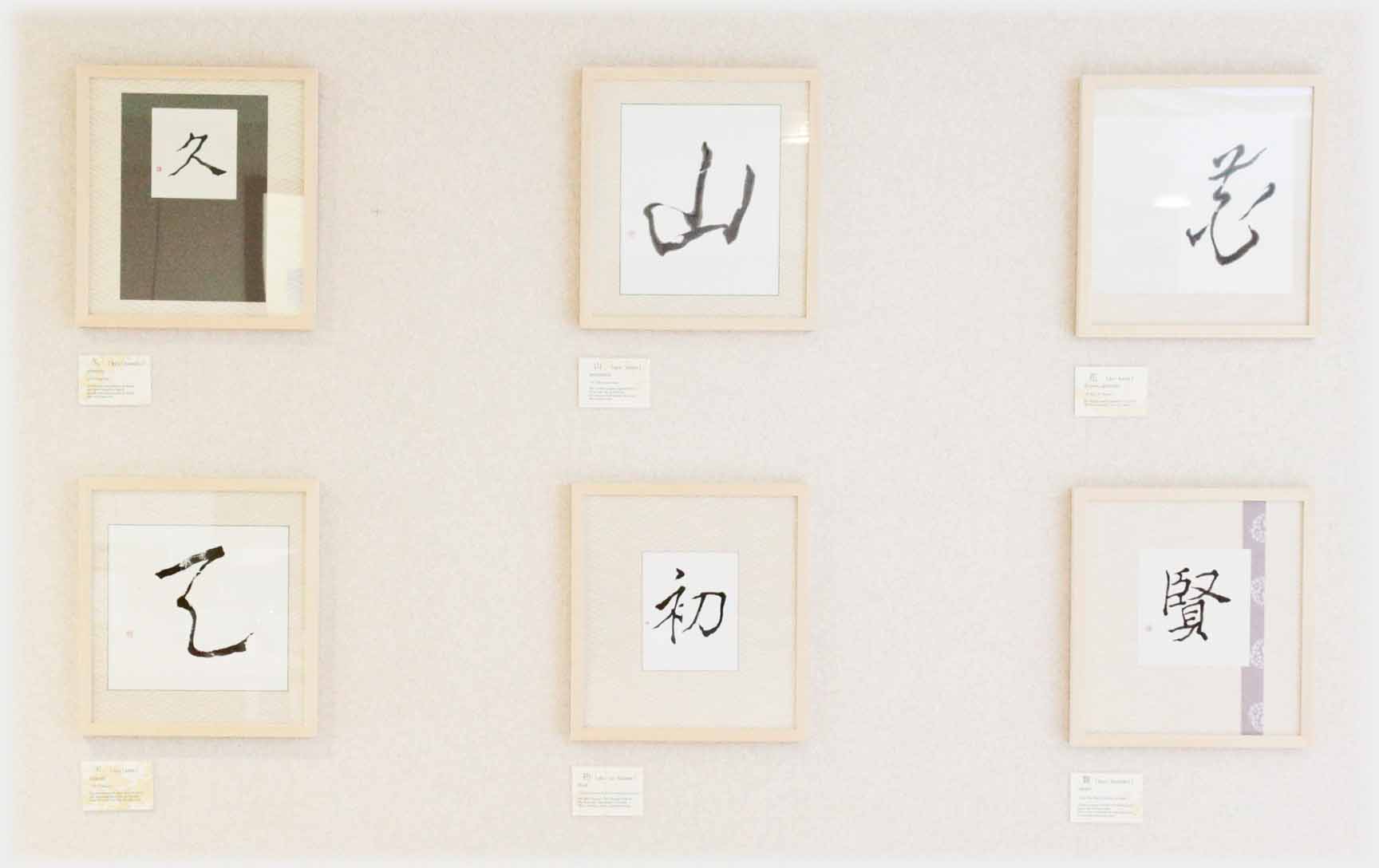 Six framed characters handing on wall.