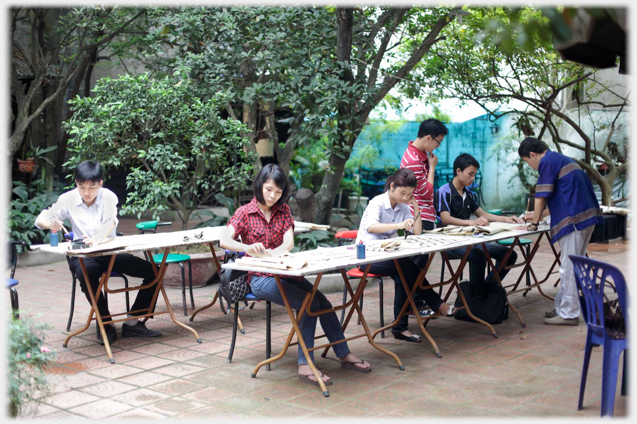 Class of five pupils teacher at one of the trestle tables.