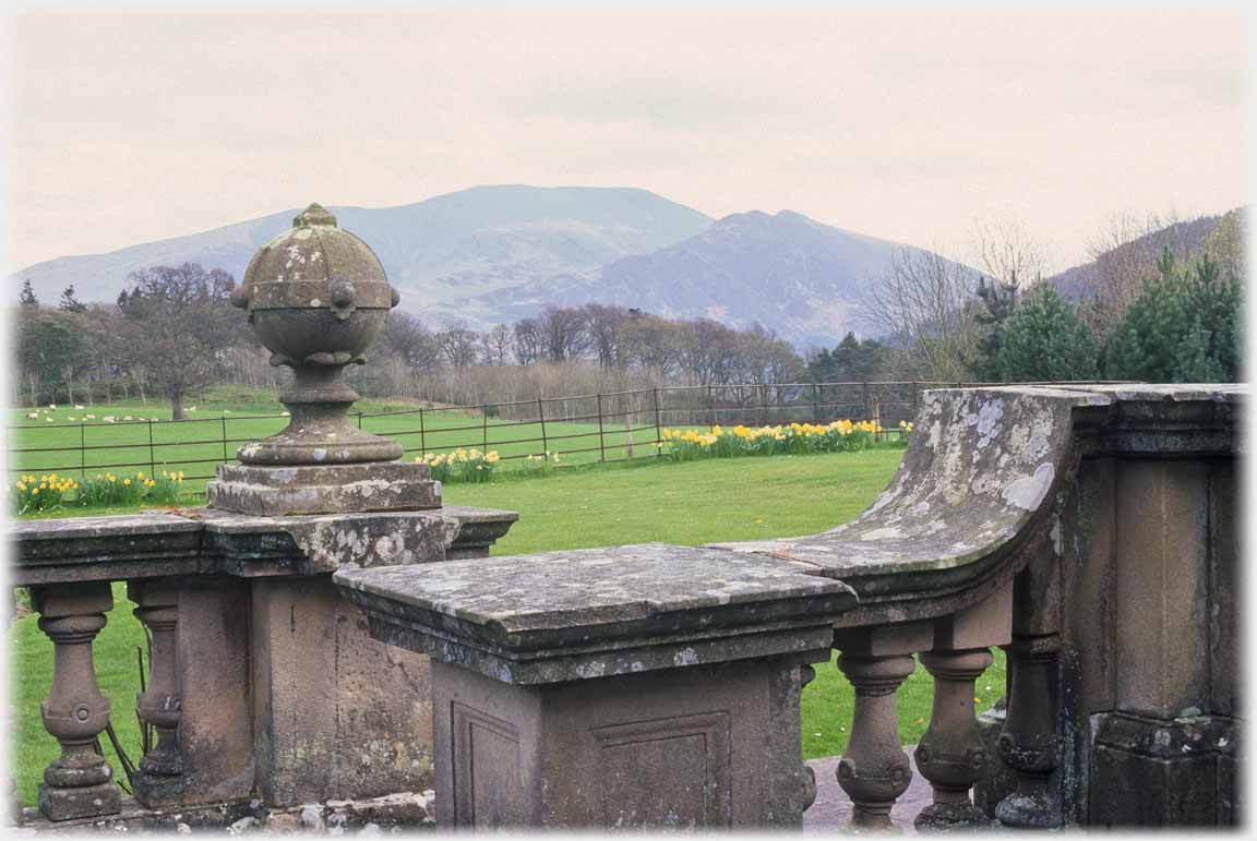 Balustrade with finial and mountain beyond.