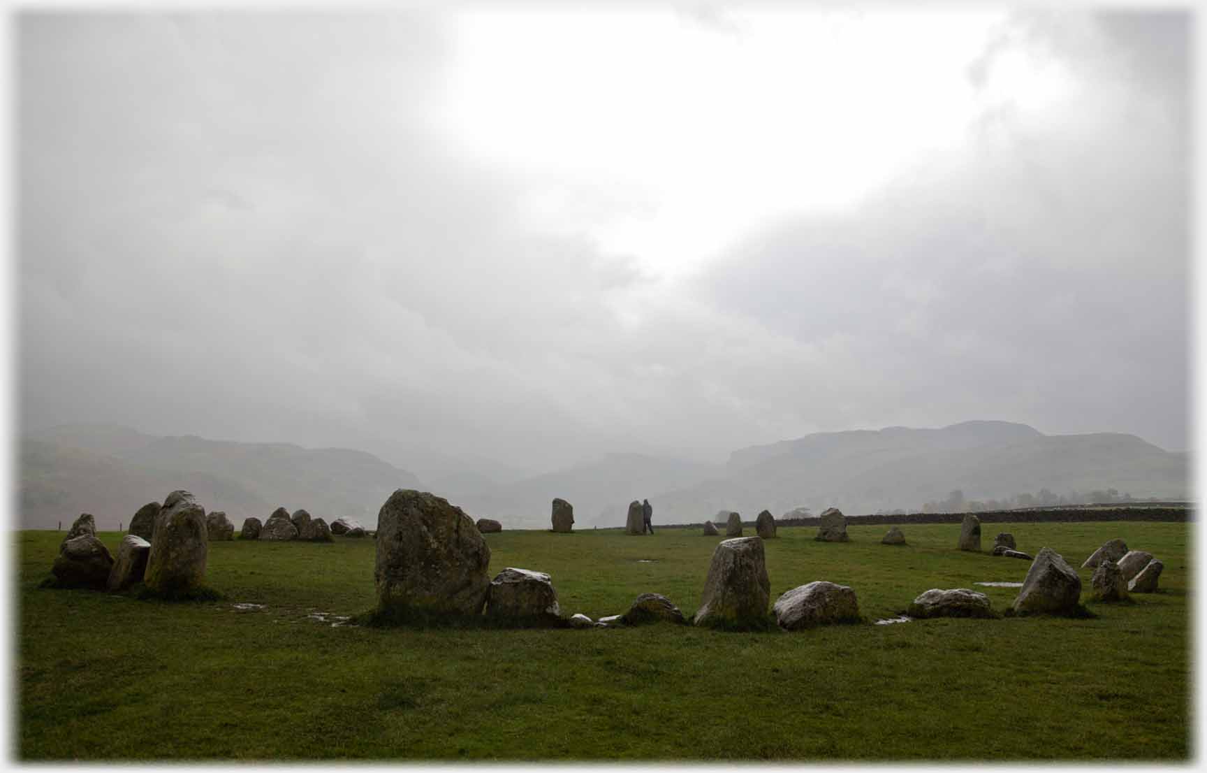 Stone circle under grey sky.