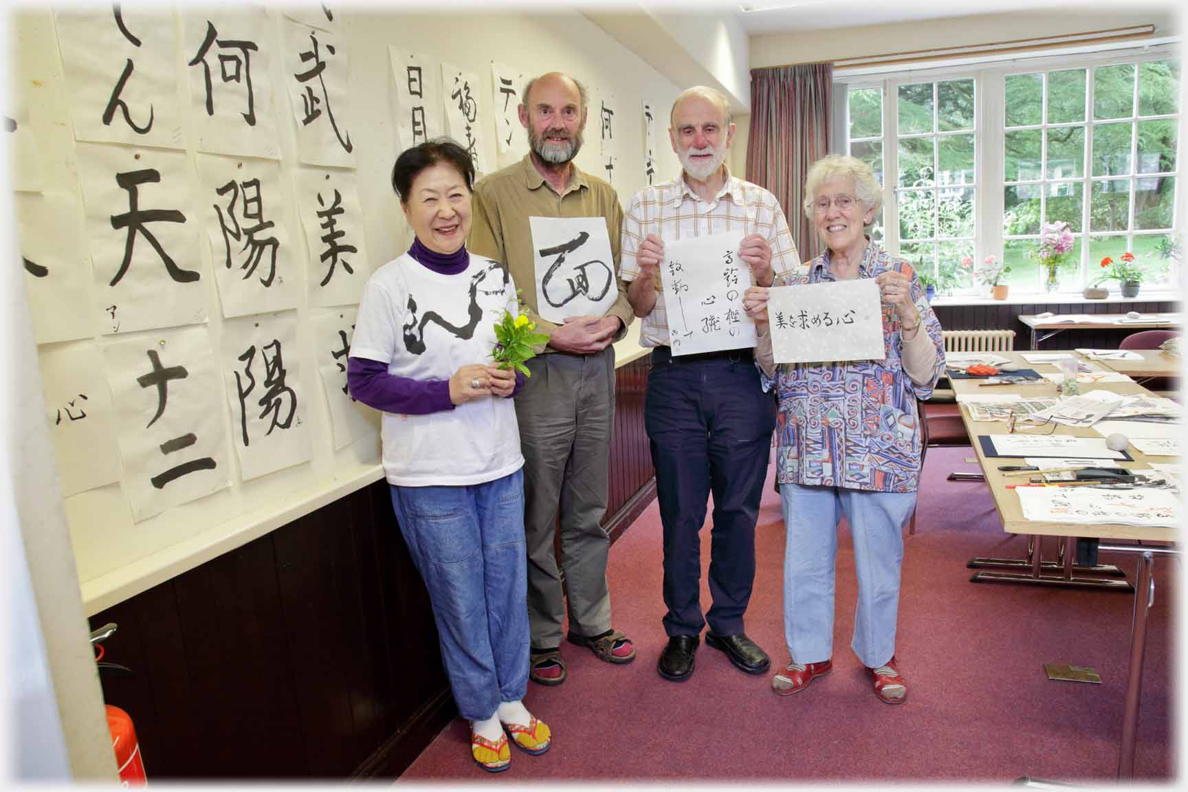 Teacher, and three class members holding their work.