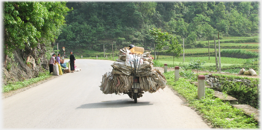 Motorbike laden with paper refuse.