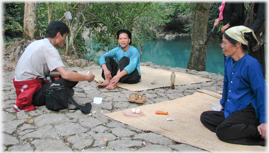 Two women sitting on mats with Han and eggs.