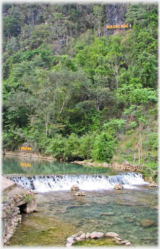 Steep hillside with the Suoi Le Nin sign down by river and the Nui cac Mac high above.