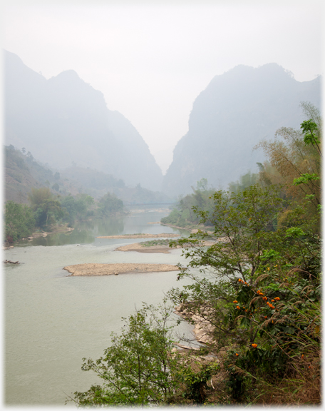 River disappearing into light mist between karsts.