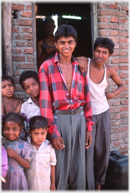 Men and children in front of house.