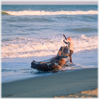 Man beside log boat.