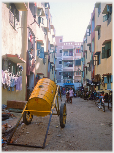 Blocks of flats, wheeled oildrum in the foreground.