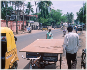 Tricycle carrier in foreground, street beyond.