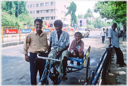 Tricycle carrier, two men and child.