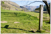 Signpost along valley with barn.