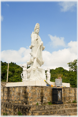 Statue with donations safe beside it.