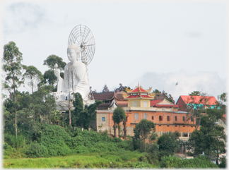 A side view of the Van Hanh Buddha showing the monastery buildings.