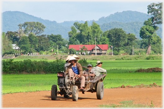 People in a trailer pulled by portable motor.