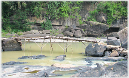 Slimly supported, parapetless plank bridge.