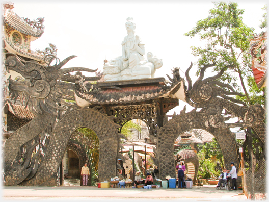 The side entrance through the curves of a dragon with a Buddha over the gateway.