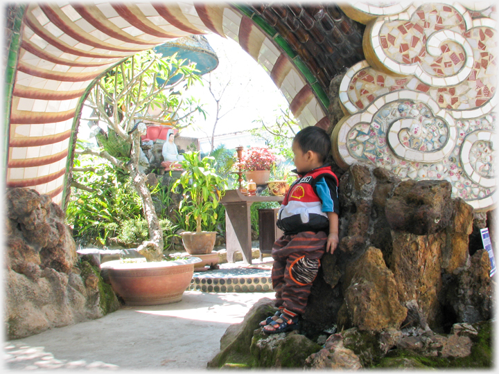 Arch formed by the body of the dragon looking into the courtyard, small boy standing looking in.