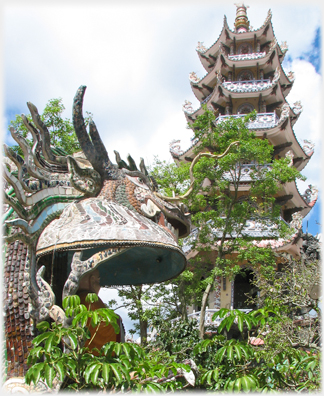 Side view of the courtyard dragon's heas with the bell tower beyond.