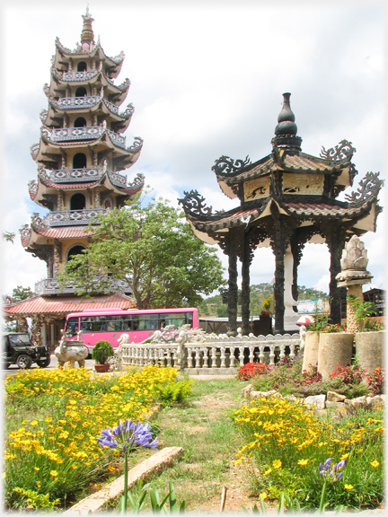 Bell tower with small pavilion sheltering Buddha figure.