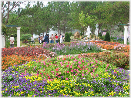 Packed beds of flowers with people beyond.