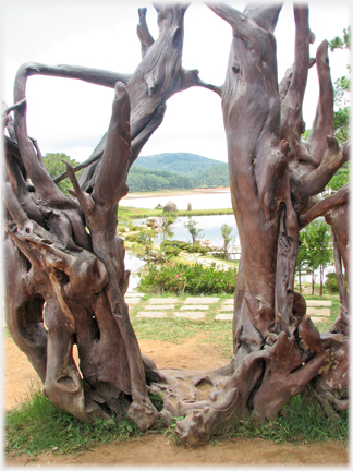 Two dead trees with lake beyond.