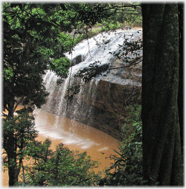 Water falling clear of the rocks into a pool.