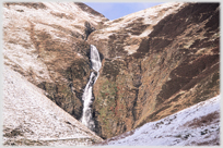 Waterfall with snow on surrounding ground.