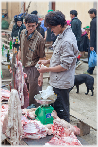 Butcher giving change to customer.