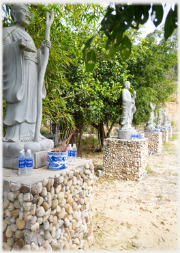 Row of five Buddhist figures with offerings at their feet.