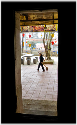 Looking out into the courtyard with woman trailing brush.