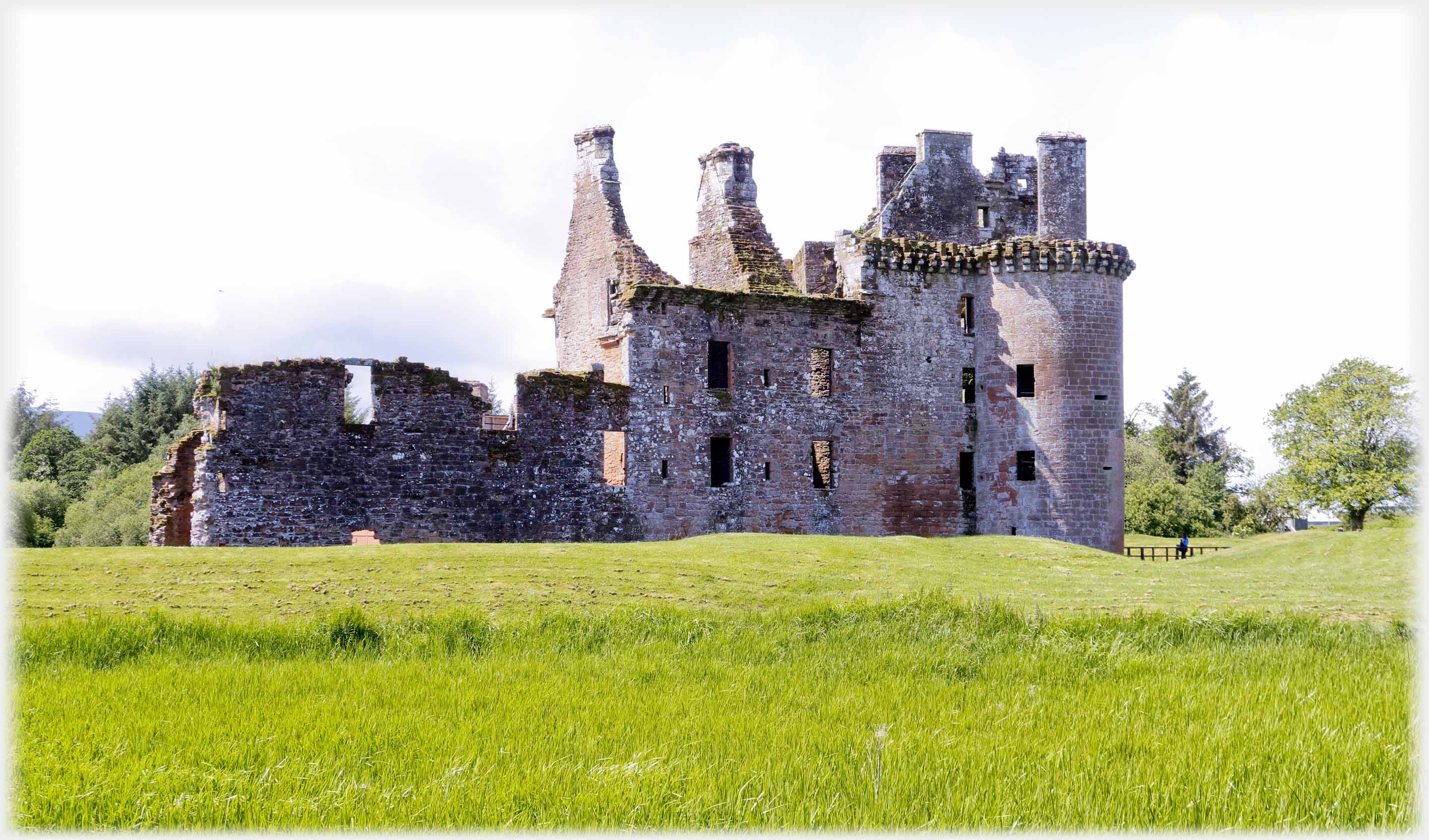 Ruined castle with grass in front.