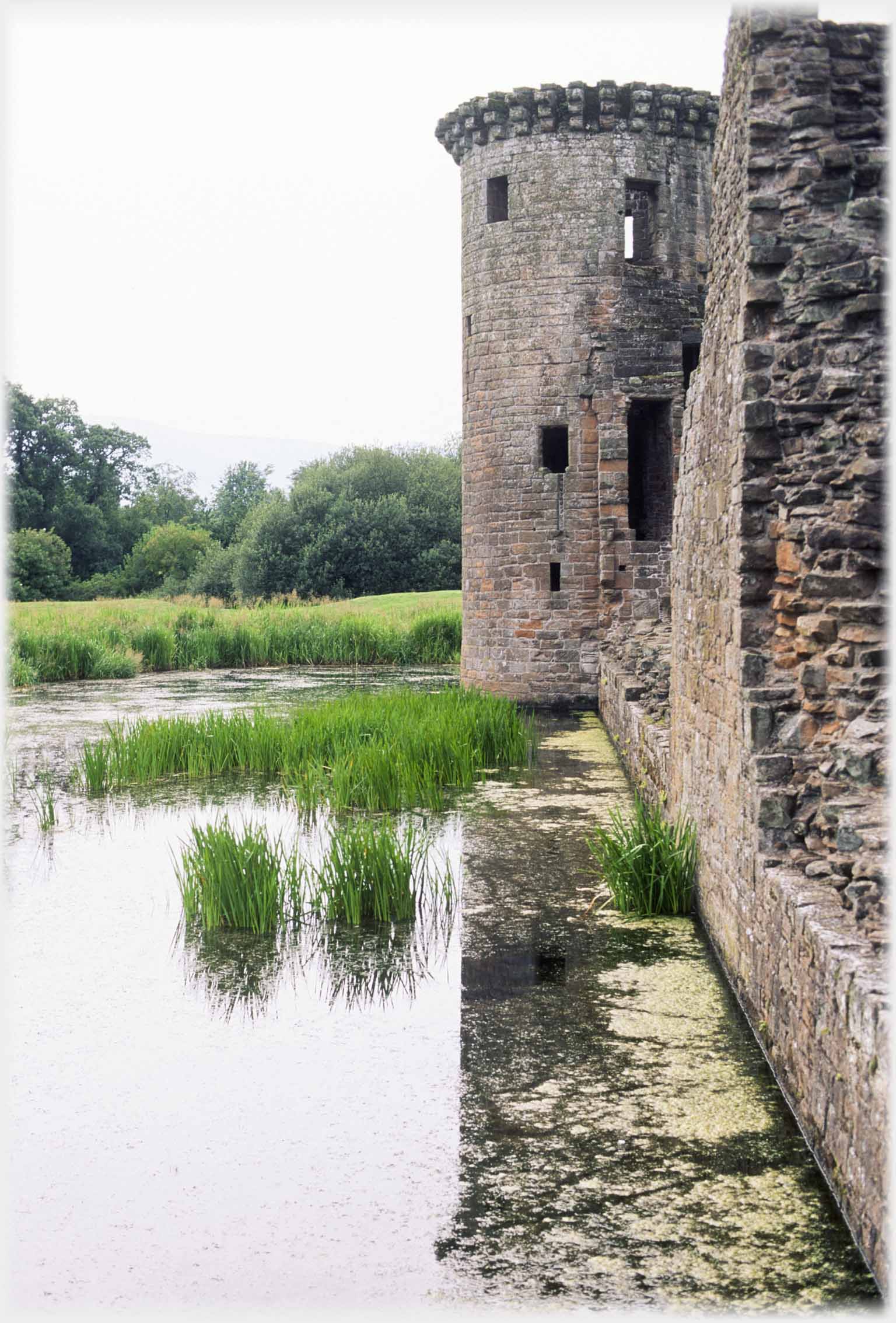 Tower and part of wall next to moat.